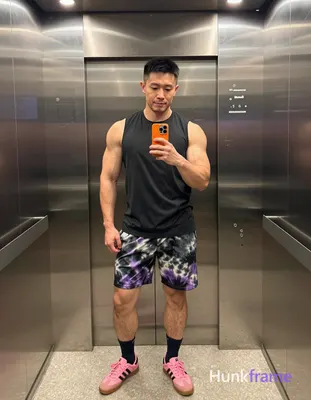 Asian man with medium-dark skin and short black straight hair stands in a full-body vertical mirror 