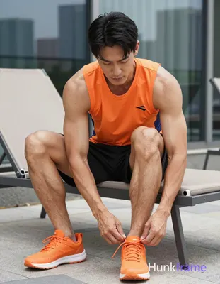 An athletic Asian man with medium-tan skin and short black straight side-parted