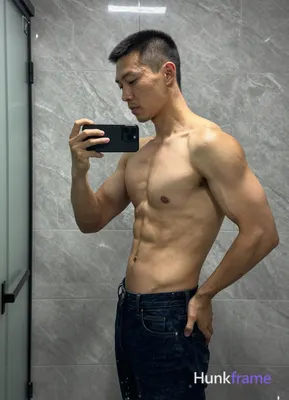 Asian man with short black buzz cut and clean-shaven face, standing sideways facing left in a high-r