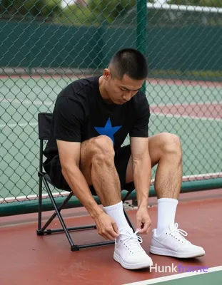 an anonymous figure man with light to medium tan skin and short black buzz cut sits on a folding cha