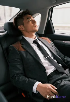 Asian man with short dark brown hair and undercut style reclining diagonally in 