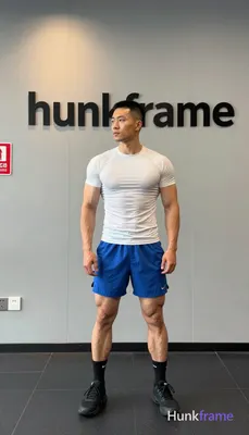 Asian man with short black buzz cut and high fade, clean-shaven face with neutral focused gaze stand