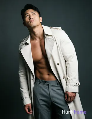 A single Asian man standing with his torso slightly leaned forward and head tilted upwards, showcasi