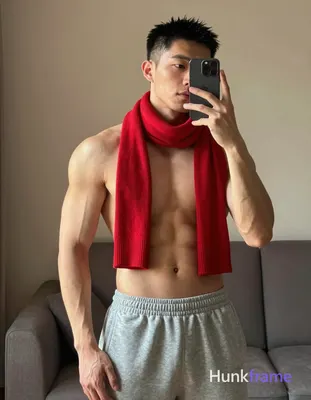 Asian man with short black hair and clean-shaven face standing in a cozy indoor 
