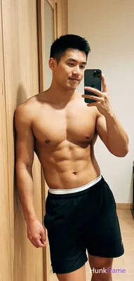 Asian muscular man with short black hair and clean-shaven face stands in a fresh lifestyle pose lean