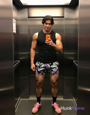 Asian man with medium-dark skin and short black straight hair stands in a full-body vertical mirror 
