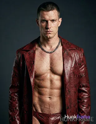 A white man with fair freckled skin and short dark cropped hair faces the camera
