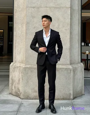 Asian man with short textured black hair styled upward and back, clean-shaven face, neutral composed