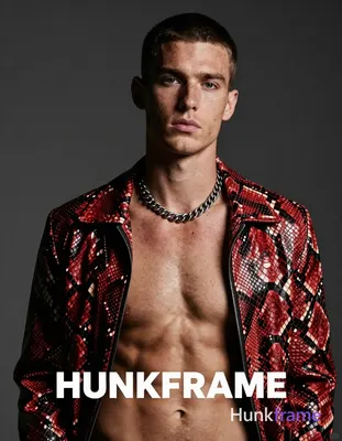 A white man with fair freckled skin and short dark cropped hair faces the camera head-and-shoulders,