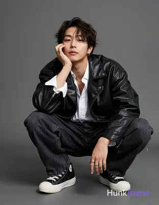 Korean adult man with medium-dark skin and dark brown chin-length tousled hair parted left He crouch