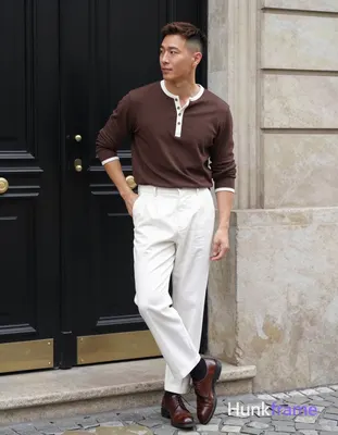 Asian man with light-medium skin and short dark brown undercut hair stands casually near the ornate 