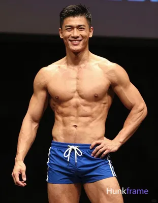 An athletic adult man with tanned skin, short dark hair styled on top and faded sides, clean-shaven 