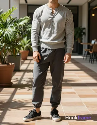 grey long-sleeve henley sweater with ribbed hem over dark grey loose-fitting trousers and black low-