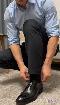 Low-angle close-up of a confident adult man crouching with knees bent, torso leaning forward out of 