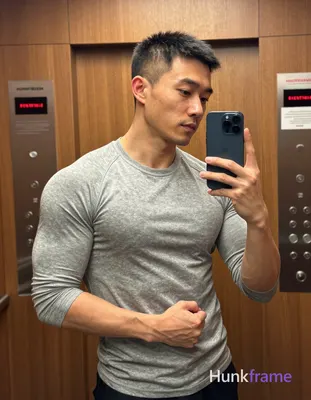 Asian man with short buzz cut, dark brown/black textured top and faded sides, cl