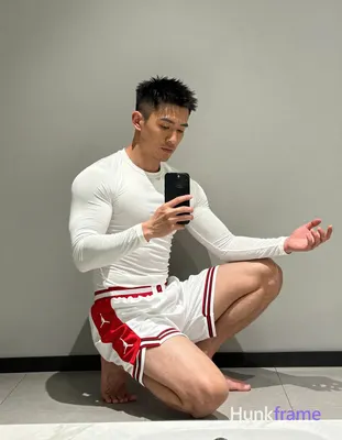 Asian man with short textured dark black hair and clean-shaven face, wearing white long-sleeve compr