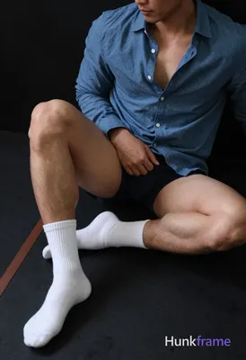 Close-up vertical portrait of an adult man seated on black rubber gym flooring, 