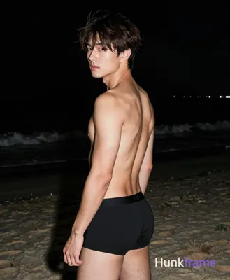 Asian man with short dark brown tousled hair and side-swept bangs, clean-shaven face, neutral seriou