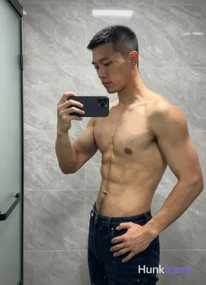 Asian man with short black buzz cut and clean-shaven face, standing sideways facing left in a high-r