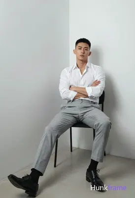 Full-bleed vertical phone wallpaper composition of an Asian man with short black hair and clean-shav