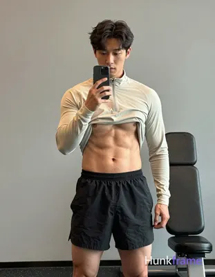 Asian man with light-medium skin and short dark wavy hair parted left, clean-sha