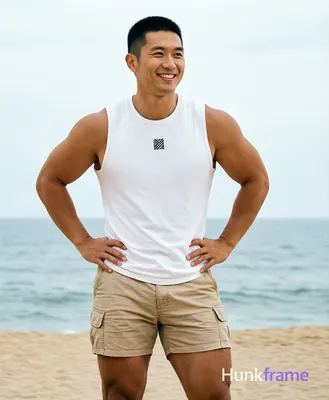 Asian man with short black buzz cut and clean-shaven face, smiling relaxedly while gazing slightly o