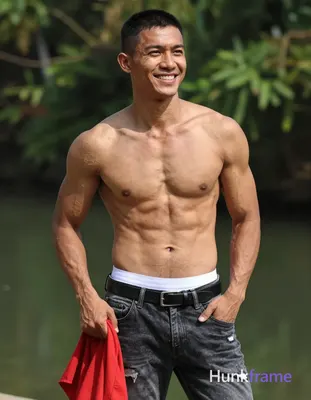 Asian man with light tan skin and short black buzz cut stands upright outdoors n
