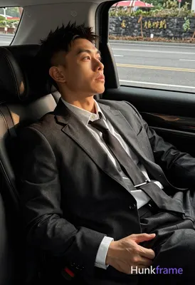 Asian man with short dark brown spiky undercut hair and clean-shaven face, neutr