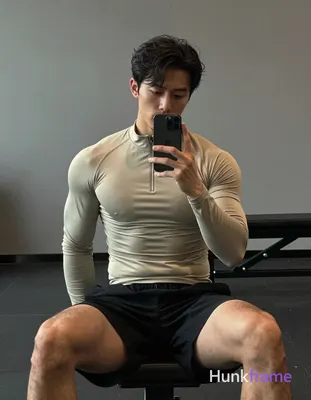 Asian man with light-medium skin and short dark wavy hair parted left, clean-shaven chin with light 