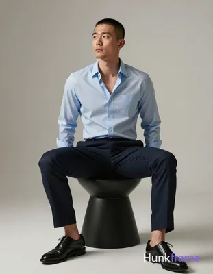 Asian adult man with short buzz cut and slight upper lip stubble, neutral contemplative gaze directe