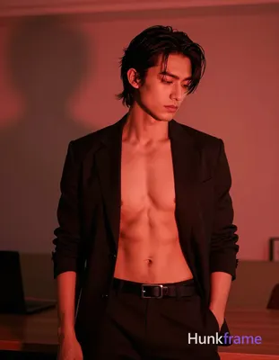 Adult man standing in a trendy urban apartment with warm red ambient lighting, s