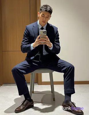 Asian man with light to medium tan skin and short textured dark hair, clean-shaven face holding a sm