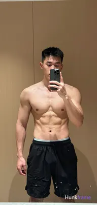 Asian muscular man with short black hair and clean-shaven face stands centered i