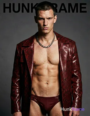 A white man with fair freckled skin and short dark cropped hair stands head-and-shoulders centered, 