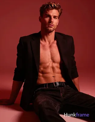 Confident adult man in tasteful suggestive framing, seated with right leg bent and left extended und
