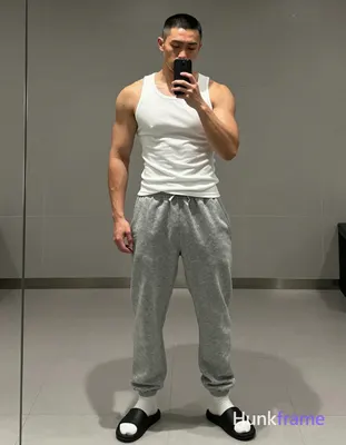an anonymous figure man with short black buzz cut and light jawline stubble poses in a tasteful sugg