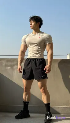 He wears tight-fitting light beige compression t-shirt with small red logo, black athletic shorts mi