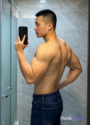 Asian man with short black buzz cut and clean-shaven face, standing sideways facing left in a candid