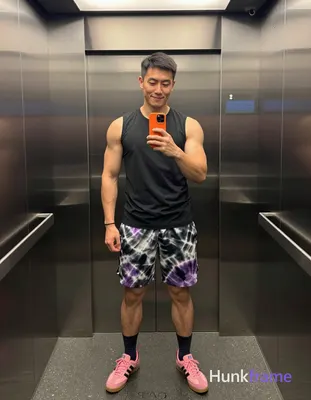 Asian man with medium-dark skin and short black straight hair stands in a full-body vertical mirror 