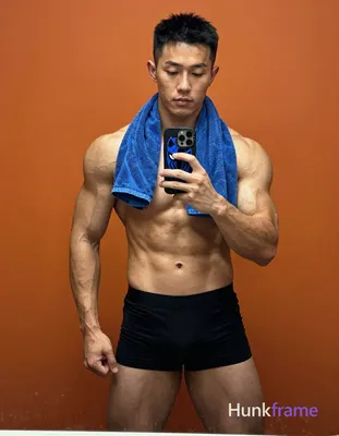 Asian man with light to medium tan skin and short black hair stands facing a mir