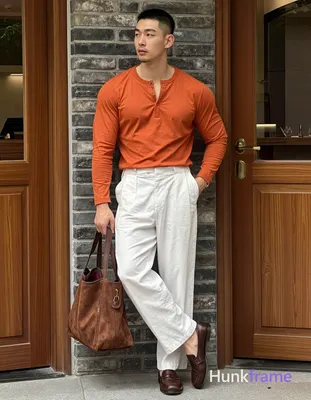 Asian man with short buzz cut and minor chin stubble stands in relaxed contrapposto, weight on right