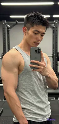 Asian man with short spiky black hair and clean-shaven face, broad muscular build standing in profil