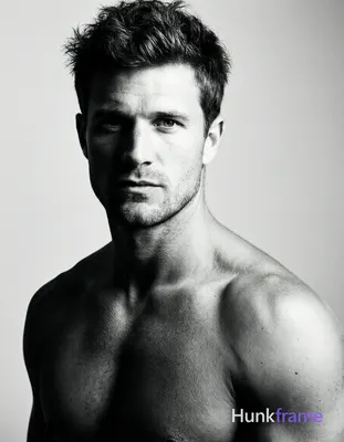 Caucasian man with short dark tousled hair, clean-shaven face, direct gaze and neutral mouth. Shirtl