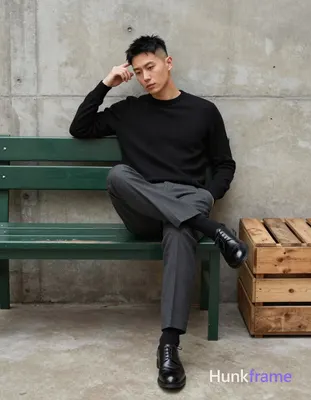 Asian man in athletic photography, seated full-body shot against textured concre