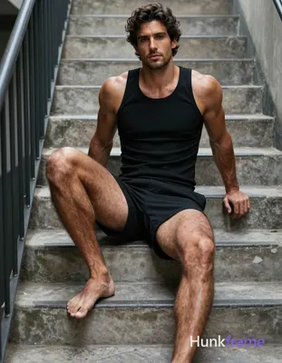Vertical mid-shot wallpaper composition of a very muscular adult man seated on c