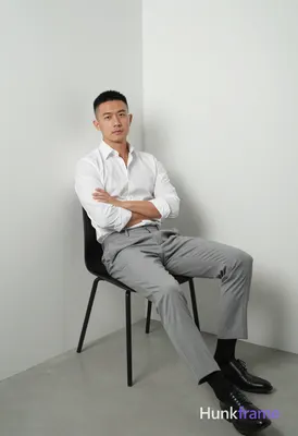 Full-bleed vertical phone wallpaper composition of an Asian man with short black hair and clean-shav