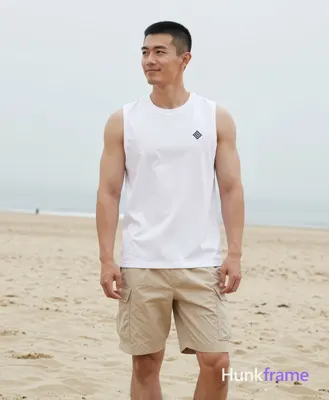 Asian man with short black buzz cut and tapered sides standing upright on a sandy beach under overca