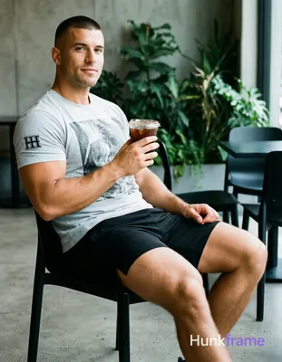 an anonymous figure adult man with light medium tan skin and short black buzz cut seated sideways on