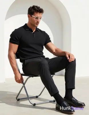 A handsome adult man with medium-dark skin and short textured dark hair sits on 