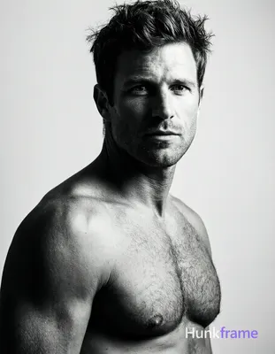 Caucasian adult man with short dark tousled hair, clean-shaven face, direct gaze and neutral mouth.
